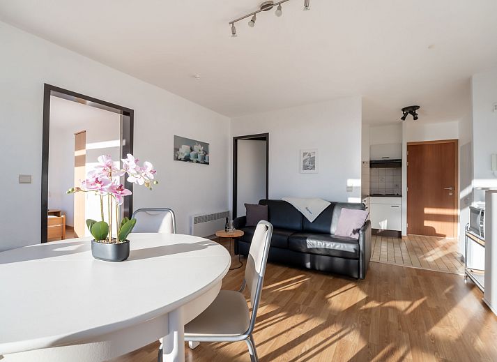 Moderne Kueche im Apartment Residentie Astrid in Bredene, Westflandern, Belgien, mit schlichten weissen Schraenken und stimmungsvoller Beleuchtung.