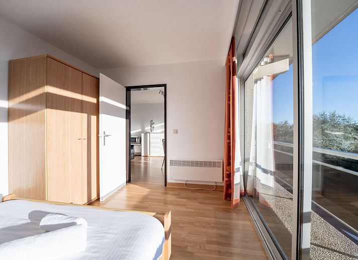 Moderne Kueche im Apartment Residentie Astrid in Bredene, Westflandern, Belgien, mit schlichten weissen Schraenken und stimmungsvoller Beleuchtung.