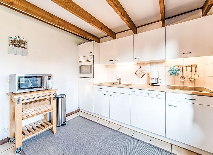 Gezellige woonkamer van Vakantiehuis Vissershuisje nr.178 in Bredene, West-Vlaanderen, met houten balken en comfortabele zithoek.