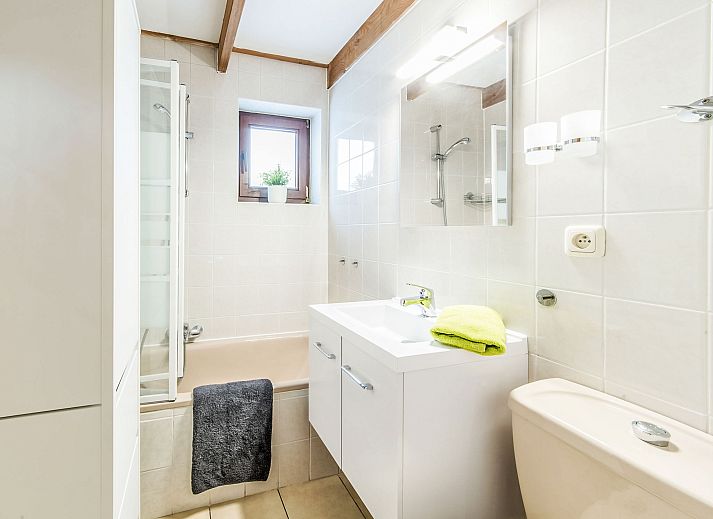 Gezellige eetkamer in Vakantiehuis Vissershuisje nr.178 in Bredene, West-Vlaanderen, Belgie met houten meubels en open keuken.