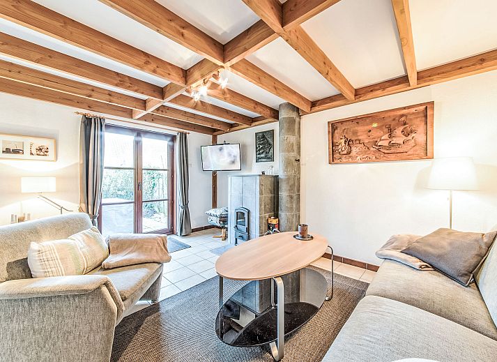 Gezellige eetkamer in Vakantiehuis Vissershuisje nr.178 in Bredene, West-Vlaanderen, Belgie met houten meubels en open keuken.
