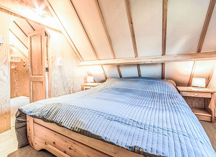 Gezellige eetkamer in Vakantiehuis Vissershuisje nr.178 in Bredene, West-Vlaanderen, Belgie met houten meubels en open keuken.