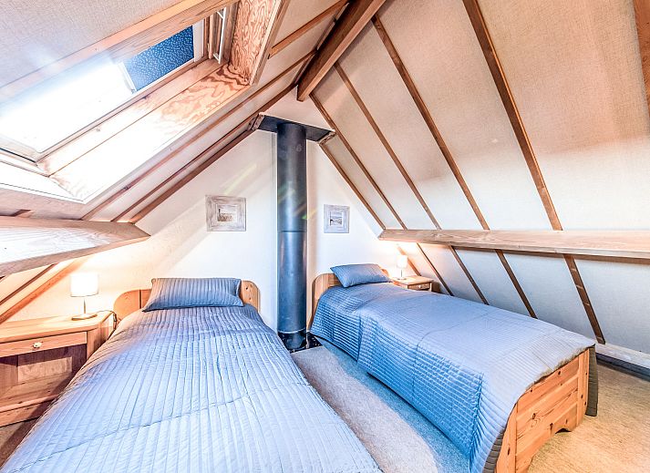 Gezellige eetkamer in Vakantiehuis Vissershuisje nr.178 in Bredene, West-Vlaanderen, Belgie met houten meubels en open keuken.
