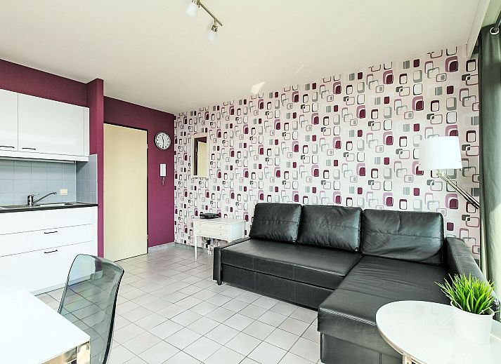 Stilvolles Wohnzimmer des Apartment Studio 604 in Bredene, Belgien, mit moderner Einrichtung und Blick auf die Terrasse und die Umgebung.