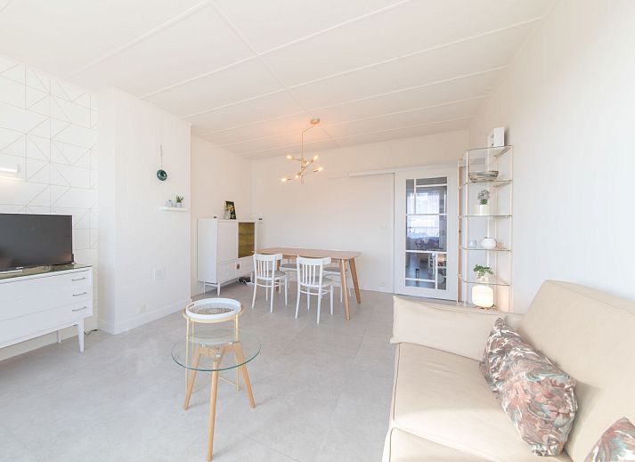 Helles und modernes Wohnzimmer der Ferienwohnung Casa Bunck in Bredene, Westflandern, mit gemuetlicher Sitzecke und Essbereich.
