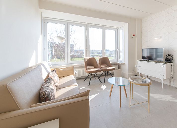 Helles und modernes Wohnzimmer der Ferienwohnung Casa Bunck in Bredene, Westflandern, mit gemuetlicher Sitzecke und Essbereich.