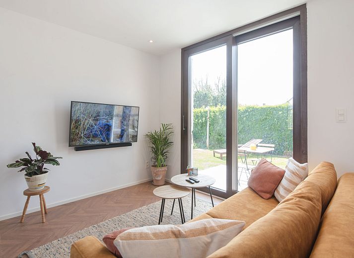 Entspannen Sie sich im Garten des Ferienhauses Hutje bij de Zee in Bredene, Westflandern, mit einem privaten Whirlpool inmitten der gruenen Natur.