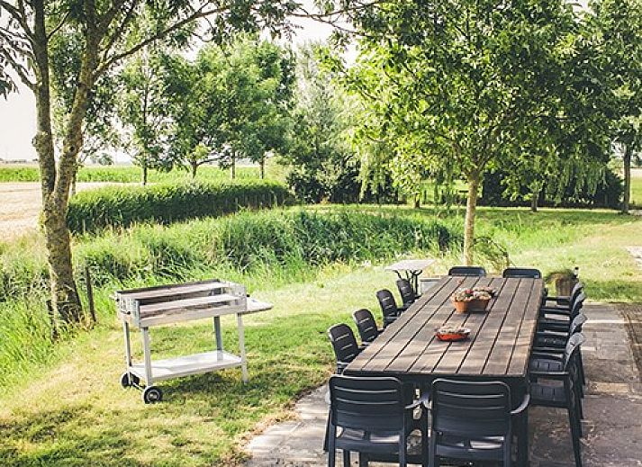 Cozy living room in Maracci vacation home Pervijze with wooden stairs and comfortable seating.