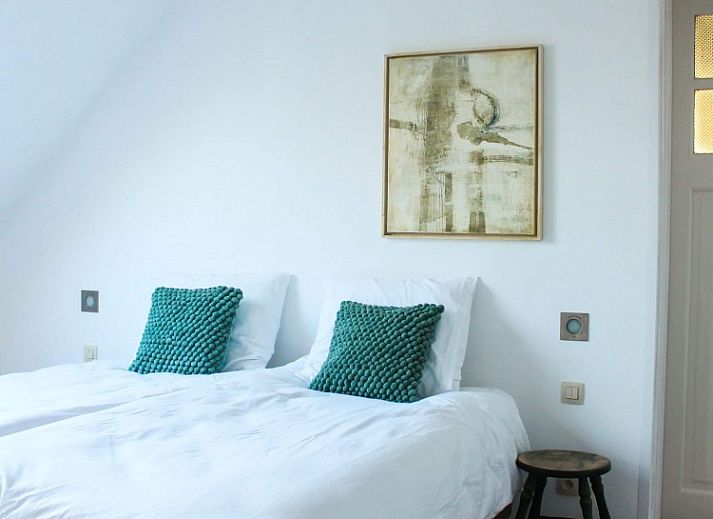 Cozy living room in Maracci vacation home Pervijze with wooden stairs and comfortable seating.