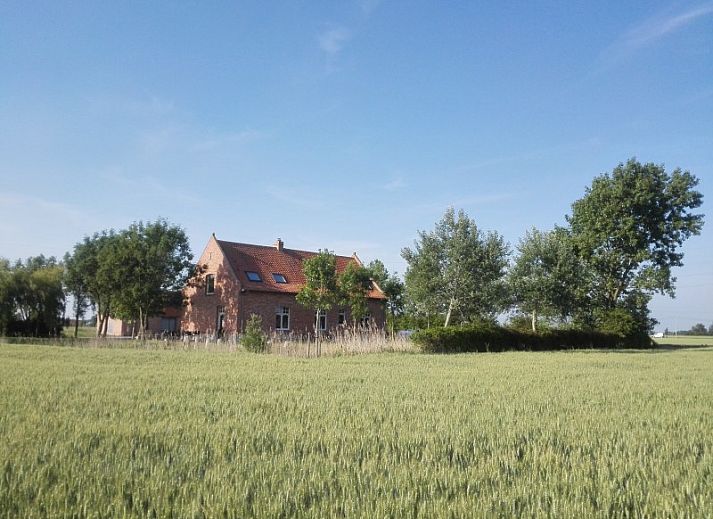 Cozy living room in Maracci vacation home Pervijze with wooden stairs and comfortable seating.