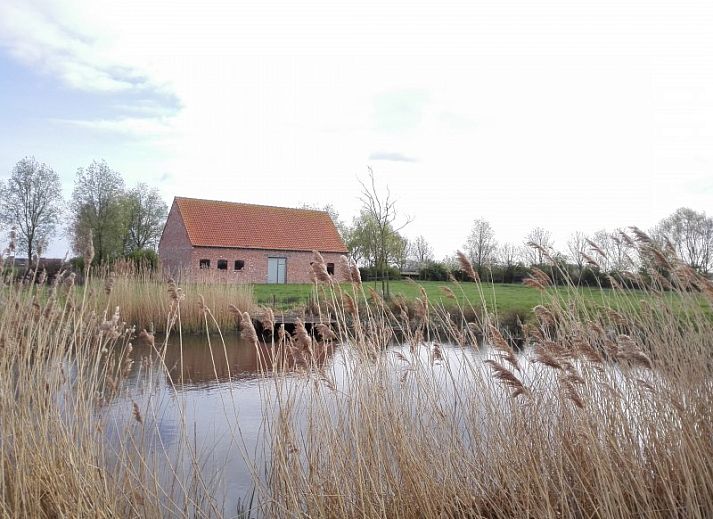 Cozy living room in Maracci vacation home Pervijze with wooden stairs and comfortable seating.