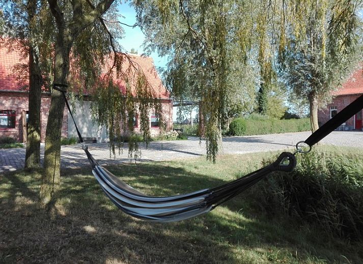 Comfortable bedroom in Maracci vacation home Pervijze with rustic wooden bench.