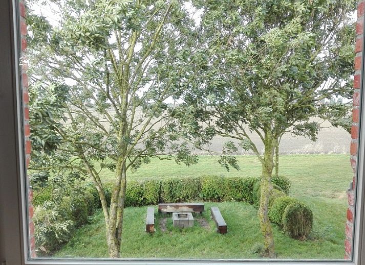 Comfortable bedroom in Maracci vacation home Pervijze with rustic wooden bench.