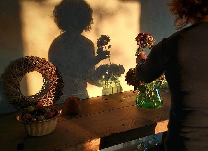 Comfortable bedroom in Maracci vacation home Pervijze with rustic wooden bench.