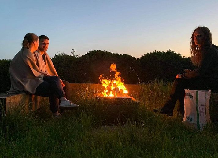 Comfortable bedroom in Maracci vacation home Pervijze with rustic wooden bench.