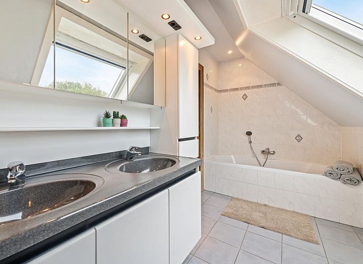 Gezellige eetkamer in vakantiehuis Frontzate te Diksmuide, West-Vlaanderen, met elegant gedekte tafel en uitzicht op de groene omgeving.