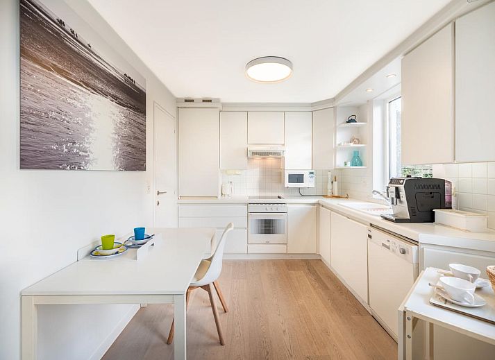 Helles Wohnzimmer des Ferienhauses La Perle in Oostduinkerke, Westflandern, mit moderner Einrichtung und Blick auf die Terrasse.