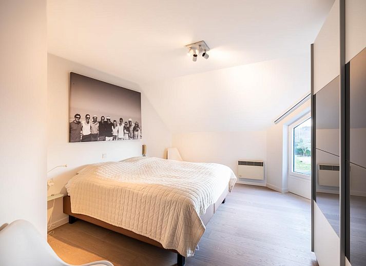 Helles Wohnzimmer des Ferienhauses La Perle in Oostduinkerke, Westflandern, mit moderner Einrichtung und Blick auf die Terrasse.