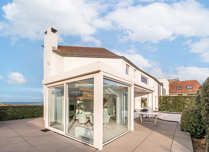 Heller Essbereich im Ferienhaus La Perle in Oostduinkerke mit Blick auf die Terrasse und die Natur von Westflandern, Belgien.
