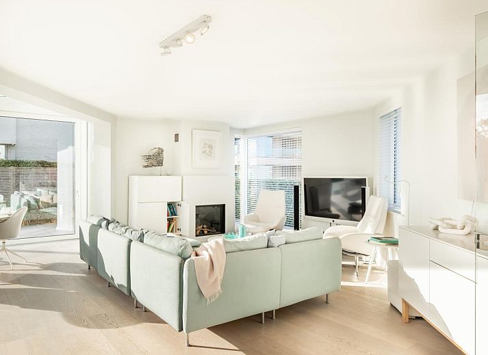 Heller Essbereich im Ferienhaus La Perle in Oostduinkerke mit Blick auf die Terrasse und die Natur von Westflandern, Belgien.