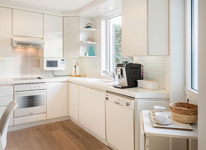 Heller Essbereich im Ferienhaus La Perle in Oostduinkerke mit Blick auf die Terrasse und die Natur von Westflandern, Belgien.