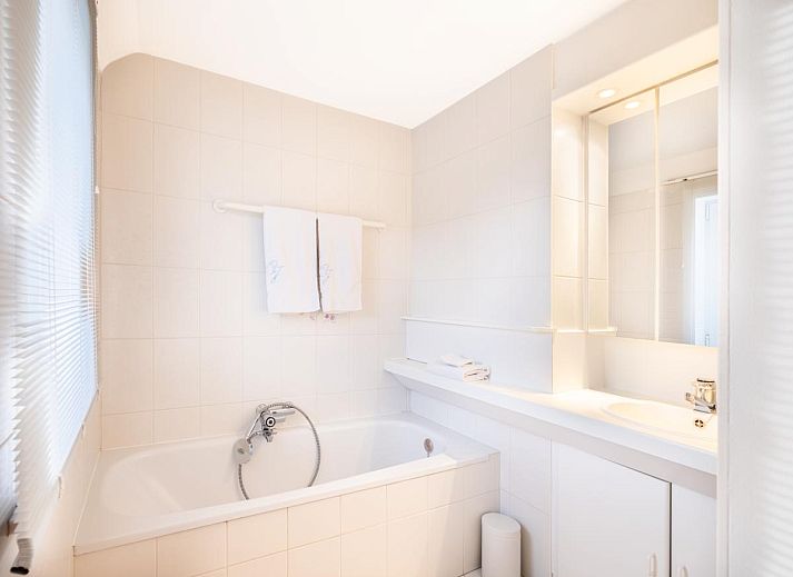 Veranda des Ferienhauses La Perle in Oostduinkerke, Westflandern, mit Blick auf den Garten und moderne Architektur.