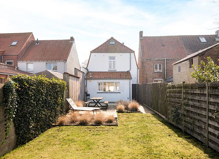 Stilvolles Wohnzimmer des Ferienhauses "Magique 31" in Oostduinkerke, Belgien, mit gemuetlicher Sitzecke und Tageslicht.