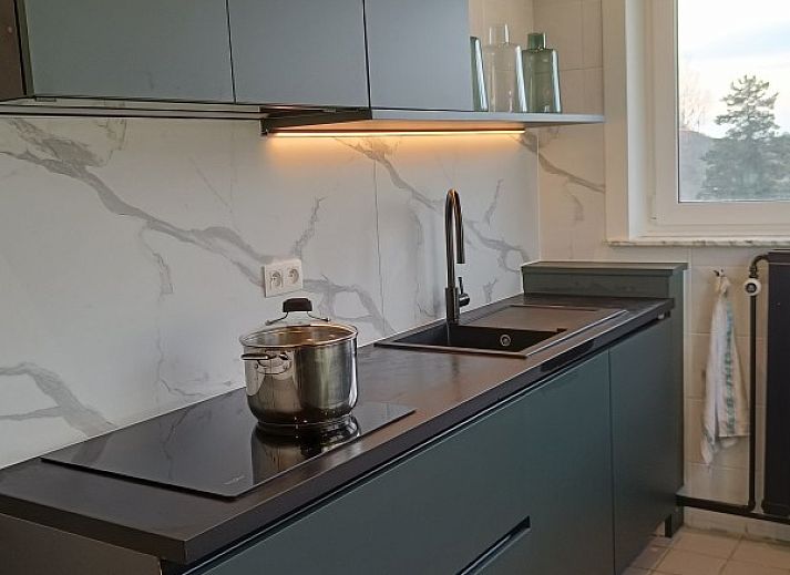 Cozy living room in Papa's Dream vacation home, Oostduinkerke, with large dining table and view of terrace.