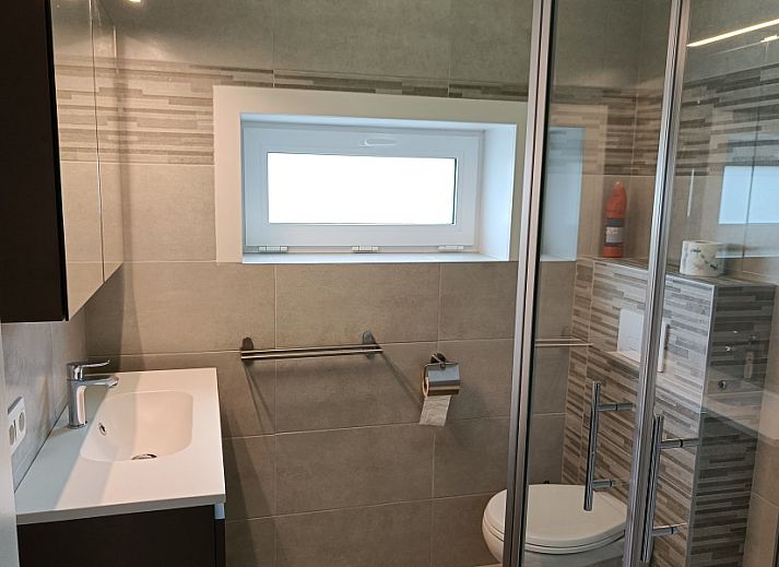 Cozy living room in Papa's Dream vacation home, Oostduinkerke, with large dining table and view of terrace.