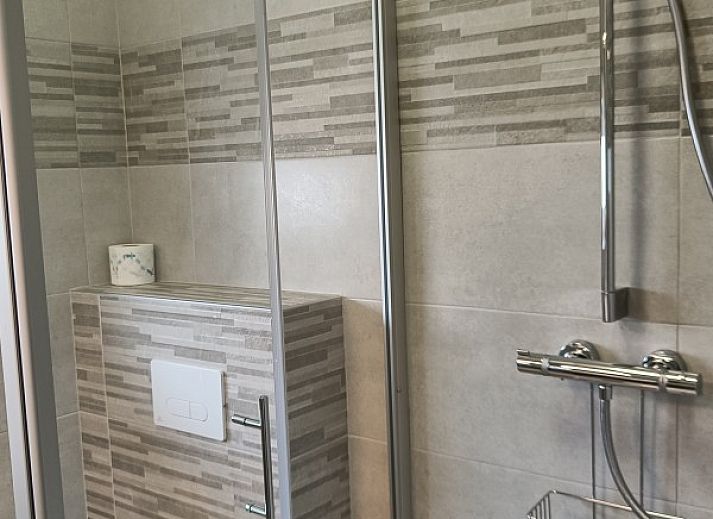 Cozy living room in Papa's Dream vacation home, Oostduinkerke, with large dining table and view of terrace.