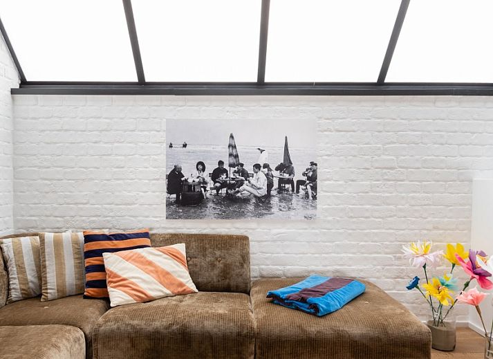 Cozy sitting area in WOWie&Germain vacation home, Oostduinkerke, with plants and colorful cushions.