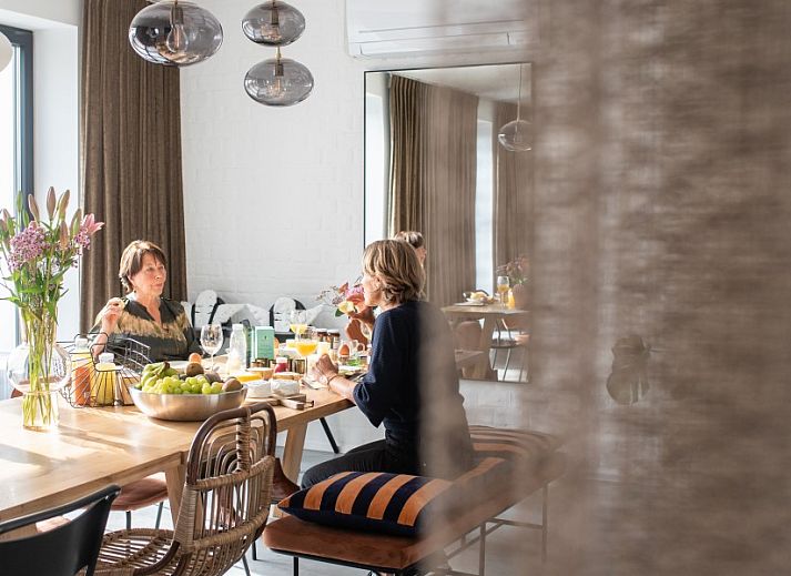 Stylish living room at WOWie&Germain in Oostduinkerke, with comfortable sofas and plenty of natural light.