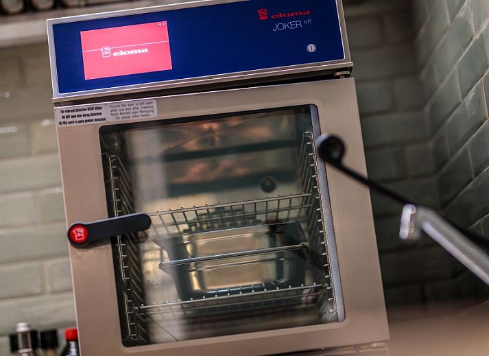Cozy corner sofa in WOWie&Germain vacation home, Oostduinkerke, with retro wall decoration.
