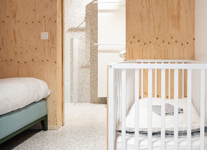 Cozy corner sofa in WOWie&Germain vacation home, Oostduinkerke, with retro wall decoration.