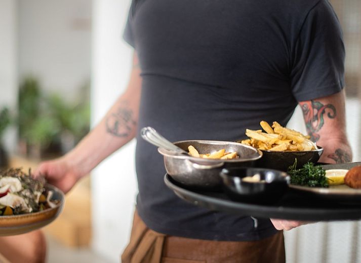 Cozy corner sofa in WOWie&Germain vacation home, Oostduinkerke, with retro wall decoration.