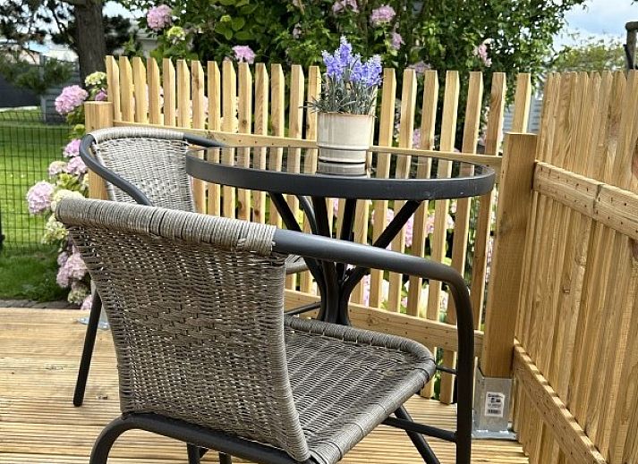 Chalet chez Dune in Oostduinkerke, een charmant vakantiehuis met houten hek en bloeiende tuin in West-Vlaanderen, Belgie.