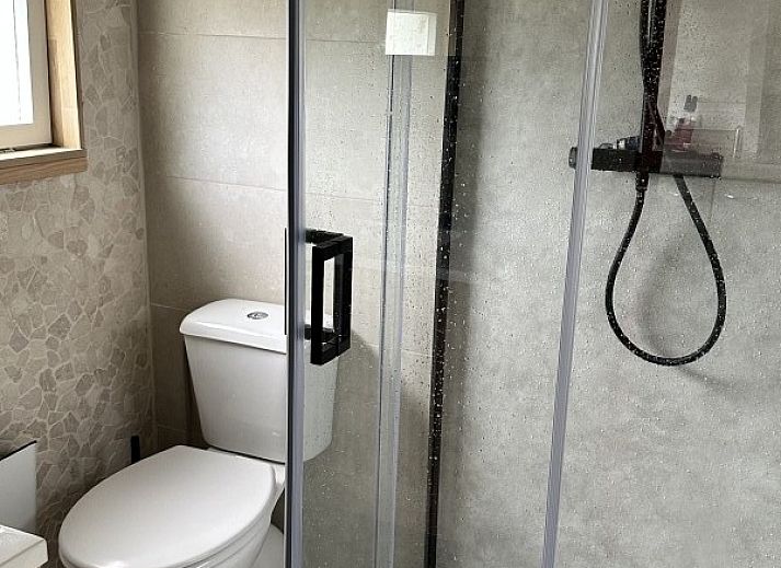 Chalet chez Dune in Oostduinkerke, een charmant vakantiehuis met houten hek en bloeiende tuin in West-Vlaanderen, Belgie.