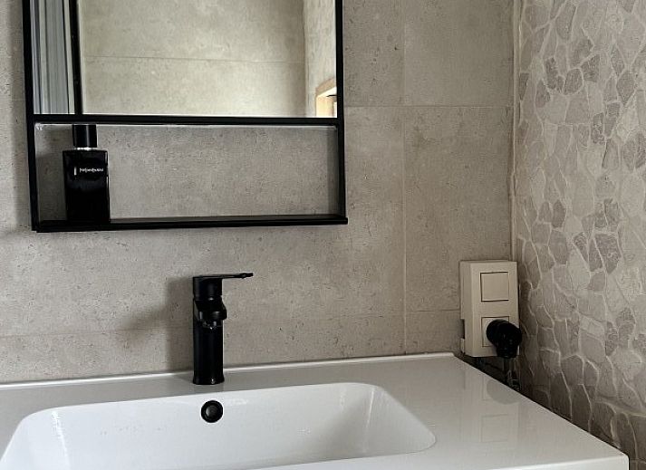 Chalet chez Dune in Oostduinkerke, een charmant vakantiehuis met houten hek en bloeiende tuin in West-Vlaanderen, Belgie.