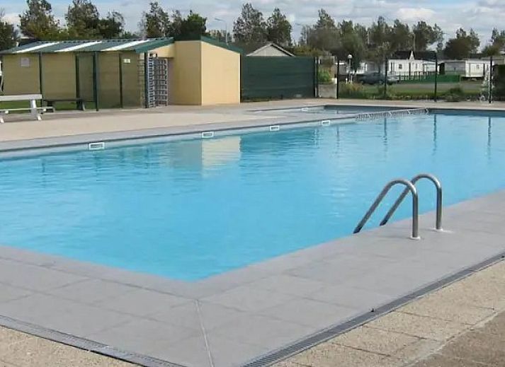 Zonnige veranda met ligstoelen bij Chalet chez Dune, Oostduinkerke, perfect voor relaxen in de natuur van West-Vlaanderen.