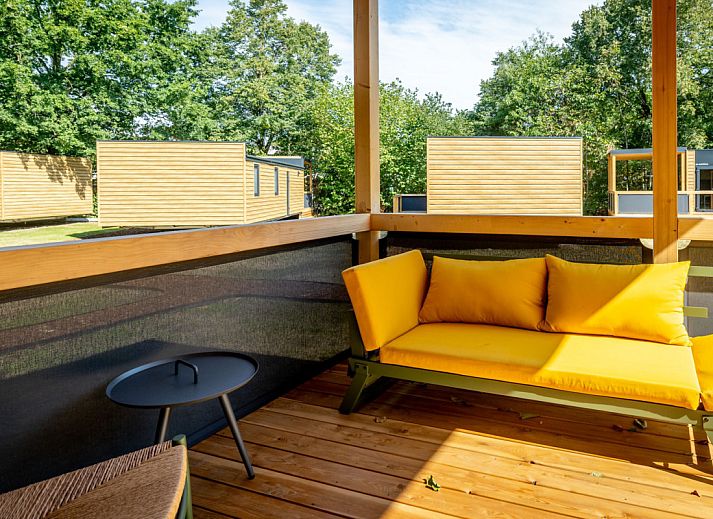 Modern eingerichtetes Lodge-Ferienhaus in Gent, Ostflandern, mit komfortablem Schlafzimmer und Essbereich.