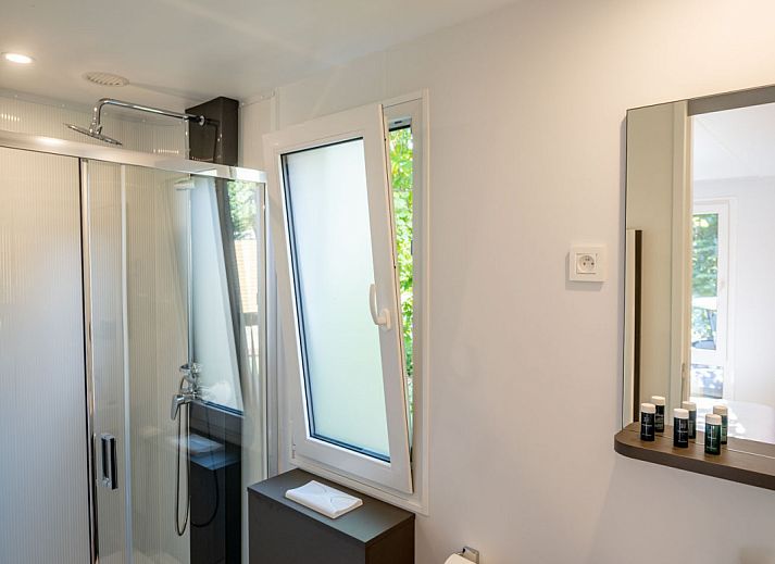 Modern eingerichtetes Lodge-Ferienhaus in Gent, Ostflandern, mit komfortablem Schlafzimmer und Essbereich.