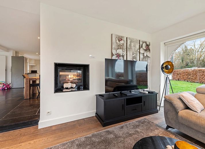 Gezellige woonkamer van Roborstje in Zwalm, Oost-Vlaanderen met kerstboom en uitzicht op de tuin.