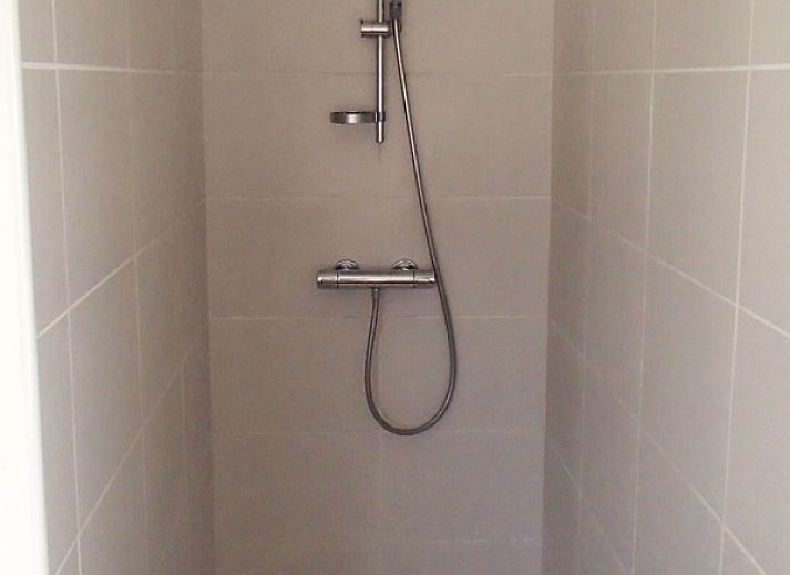 Terras van Vakantiehuis De Rekelberg in Brakel, met zitplaatsen en parasol in Belgie