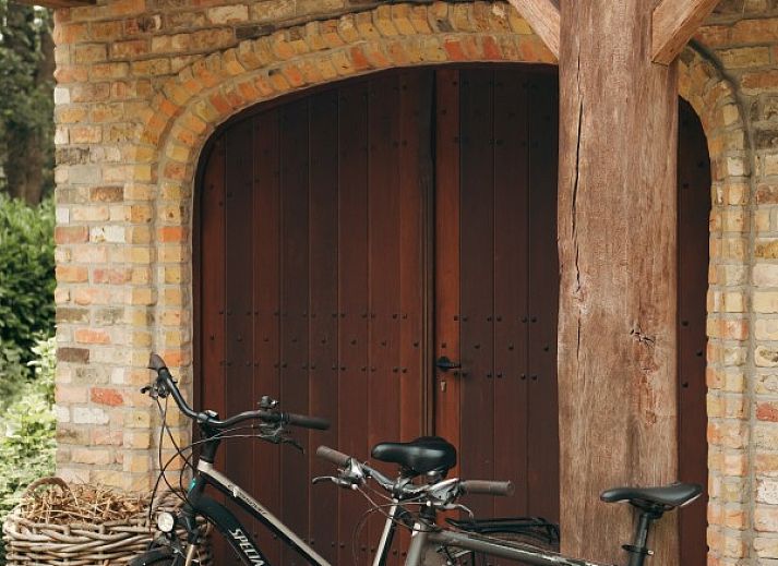 Rustikales Aeusseres des Ferienhauses La Cuesta in Ursel, Ostflandern, umgeben von Gruenflaechen.