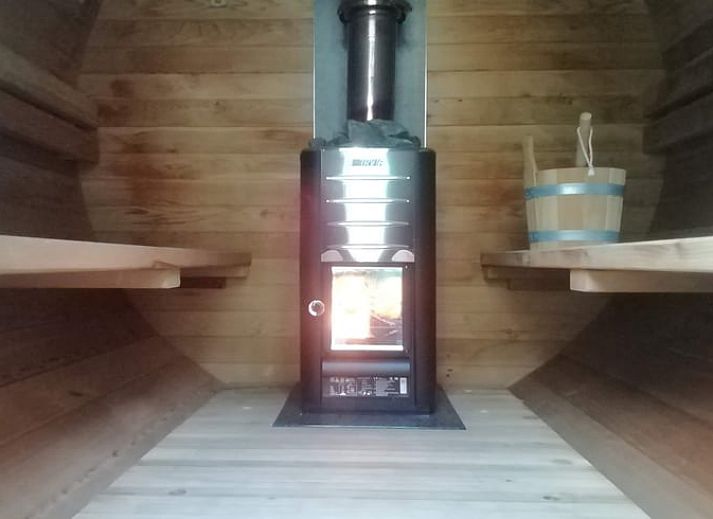 Gemuetlicher Abend auf der Veranda des Ferienhauses in Assenede, Ostflandern, stimmungsvoll beleuchtet mit bequemen Sitzgelegenheiten.