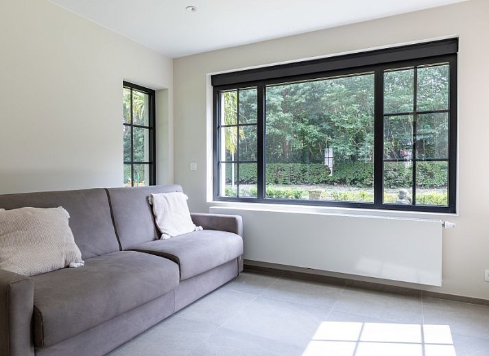Eetkamer in Villa Zonnewende, Maria-Aalter, Belgie met uitzicht op de tuin en grote ramen.