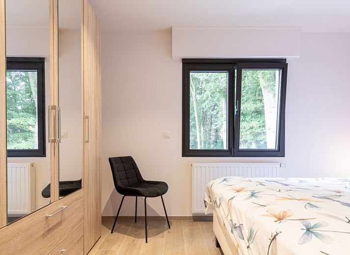 Gezellige hoek met stoel en planten in Villa Zonnewende, vakantiehuis in Maria-Aalter, Belgie.