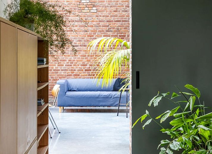 Charmante Backsteinfassade eines Ferienhauses in Sint-Pauwels, Ostflandern, mit modernem Wintergarten.