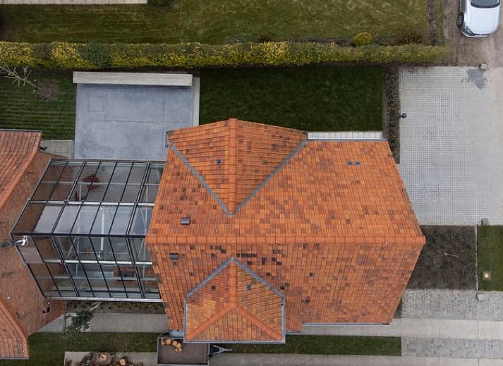 Charmante Backsteinfassade eines Ferienhauses in Sint-Pauwels, Ostflandern, mit modernem Wintergarten.