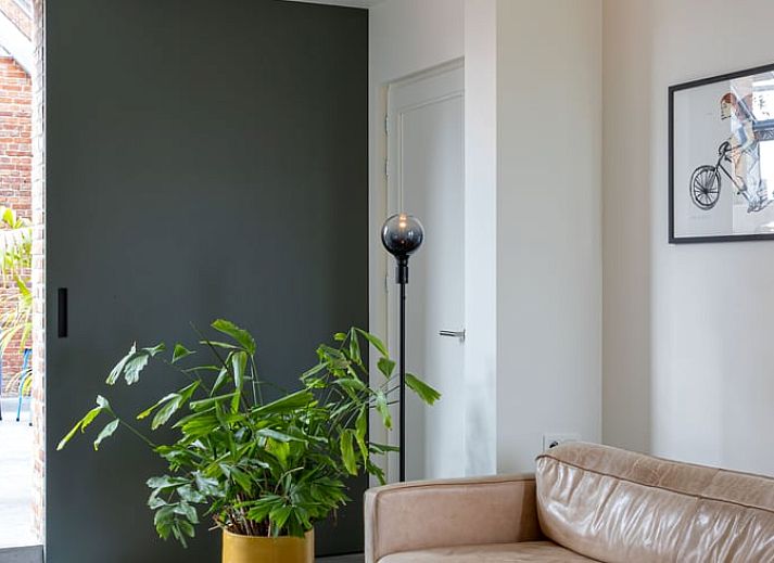 Stilvolles Esszimmer im Ferienhaus in Sint-Pauwels, Ostflandern, mit Holzmoebeln und Betonwaenden.